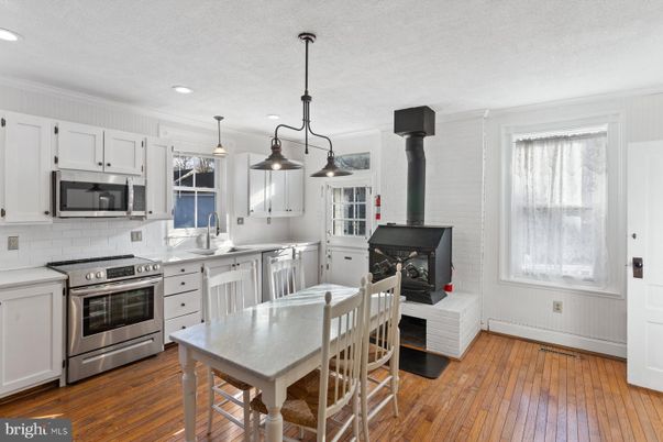 Fireplace, Interior, Kitchen, Pendant Lights, Recessed Lighting, Stainless Steel Appliances, Stone Walls, Wood Texture Flooring