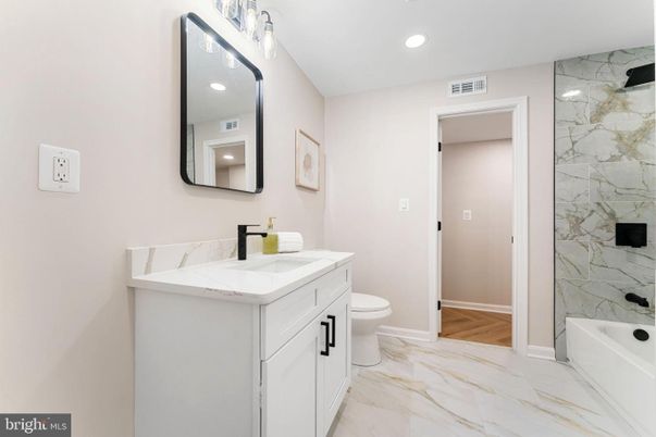 Bathroom, Dual Sink Vanities, Interior, Marble, Marble Walls, Recessed Lighting, Wood Texture Flooring