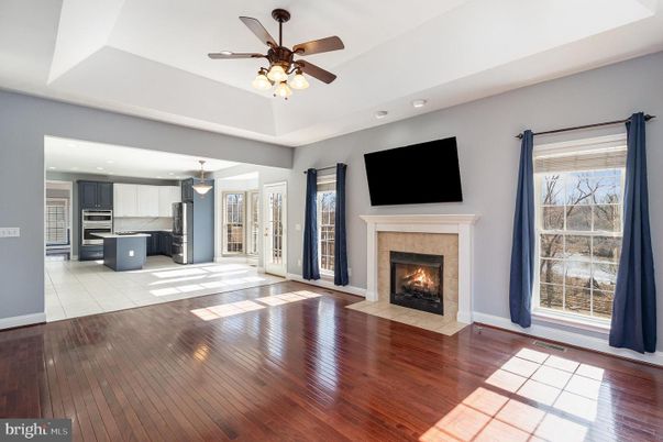 Empty room, Fireplace, Interior, Kitchen, Pendant Lights, Recessed Lighting, Stainless Steel Appliances, Wood Texture Flooring