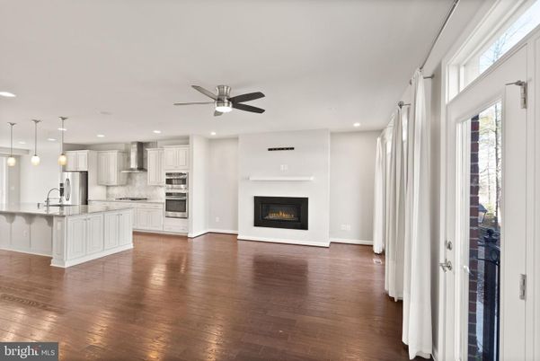 Empty room, Fireplace, Interior, Kitchen, Pendant Lights, Recessed Lighting, Stainless Steel Appliances, Wood Texture Flooring