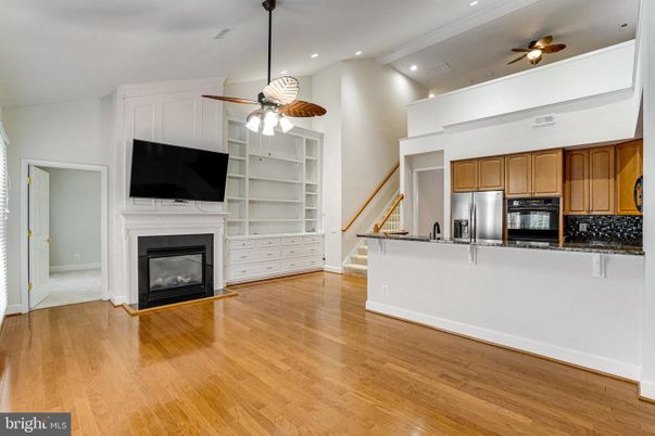 Empty room, Fireplace, Interior, Kitchen, Recessed Lighting, Stainless Steel Appliances, Wood Texture Flooring