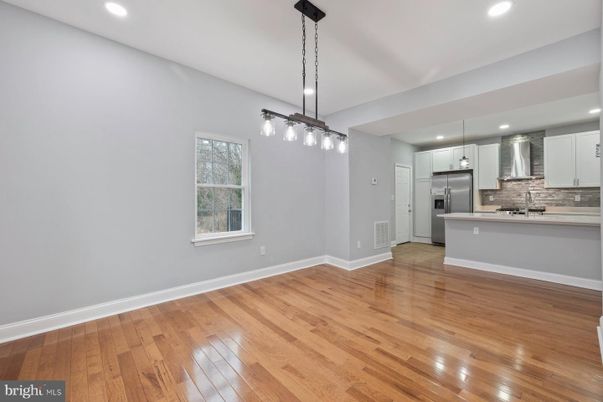 Empty room, Interior, Kitchen, Pendant Lights, Recessed Lighting, Stainless Steel Appliances, Wood Texture Flooring