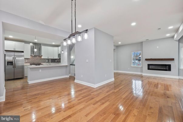 Empty room, Fireplace, Interior, Kitchen, Pendant Lights, Recessed Lighting, Stainless Steel Appliances, Wood Texture Flooring