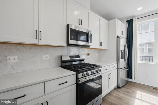 Interior, Kitchen, Marble Walls, Recessed Lighting, Stainless Steel Appliances, Wood Texture Flooring