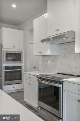 Interior, Kitchen, Marble Walls, Recessed Lighting, Stainless Steel Appliances, Wood Texture Flooring