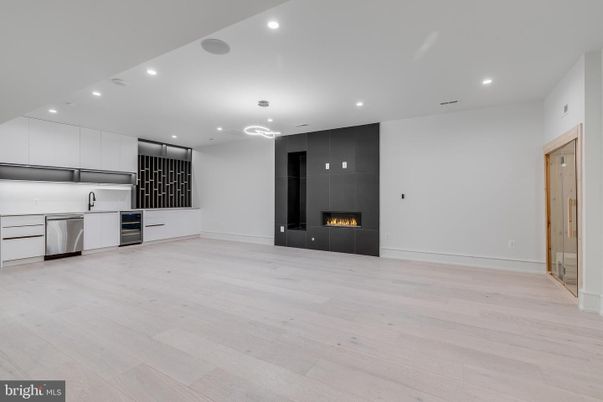 Empty room, Fireplace, Interior, Kitchen, Recessed Lighting, Stainless Steel Appliances, Wood Texture Flooring