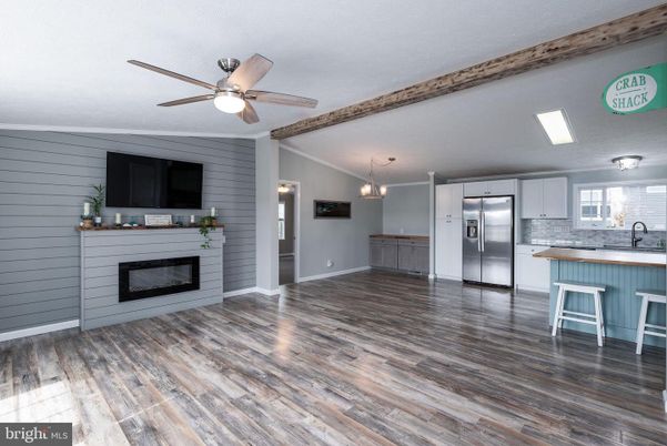 Empty room, Fireplace, Interior, Kitchen, Pendant Lights, Stainless Steel Appliances, Wood Texture Flooring