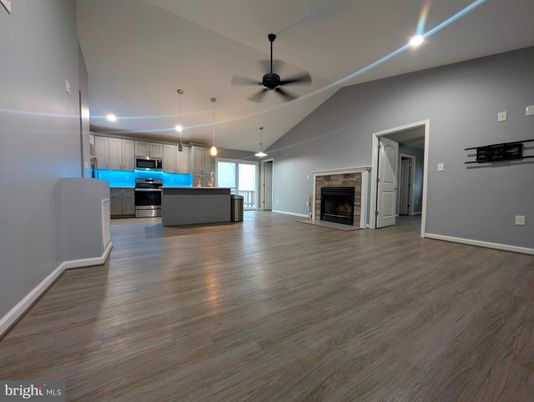 Empty room, Fireplace, Interior, Kitchen, Pendant Lights, Recessed Lighting, Stainless Steel Appliances, Wood Texture Flooring