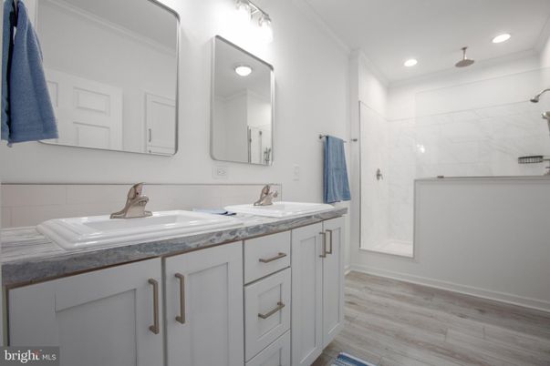 Bathroom, Dual Sink Vanities, Interior, Marble Walls, Recessed Lighting, Wood Texture Flooring