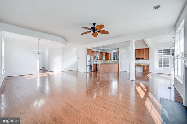 Chandelier, Empty room, Fireplace, Interior, Kitchen, Pendant Lights, Stainless Steel Appliances, Wood Texture Flooring