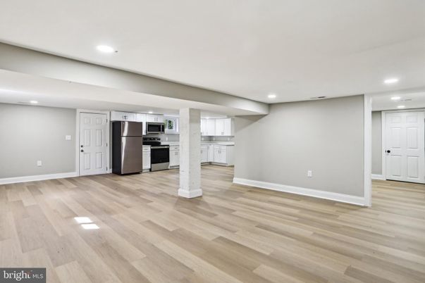 Empty room, Interior, Kitchen, Recessed Lighting, Stainless Steel Appliances, Wood Texture Flooring