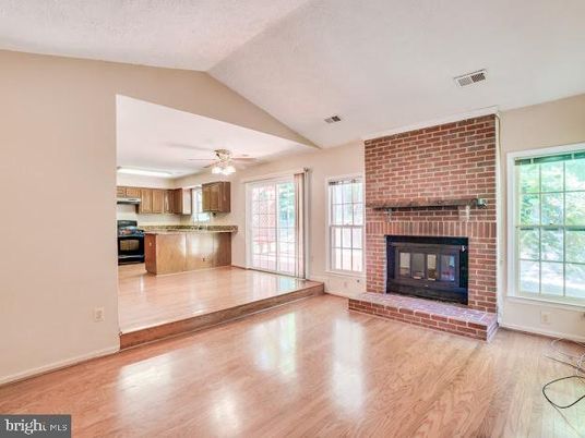 Empty room, Fireplace, Interior, Kitchen, Recessed Lighting, Stainless Steel Appliances, Stone Walls, Wood Texture Flooring