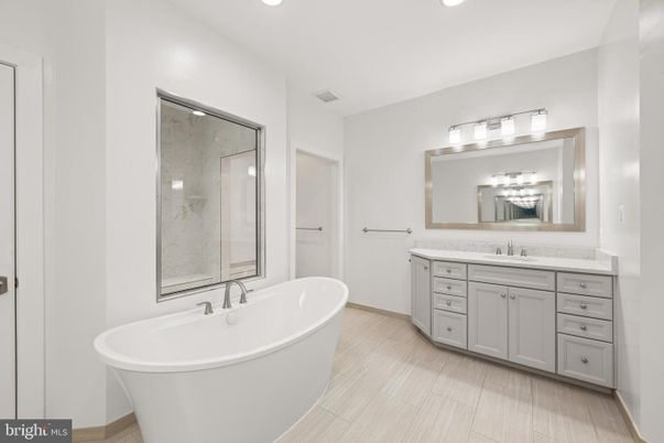Bathroom, Dual Sink Vanities, Free Standing Baths, Glass Shower, Interior, Marble Walls, Recessed Lighting, Wood Texture Flooring