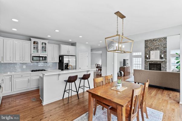 Dining room, Fireplace, Interior, Kitchen, Pendant Lights, Recessed Lighting, Stainless Steel Appliances, Stone Walls, Wood Texture Flooring