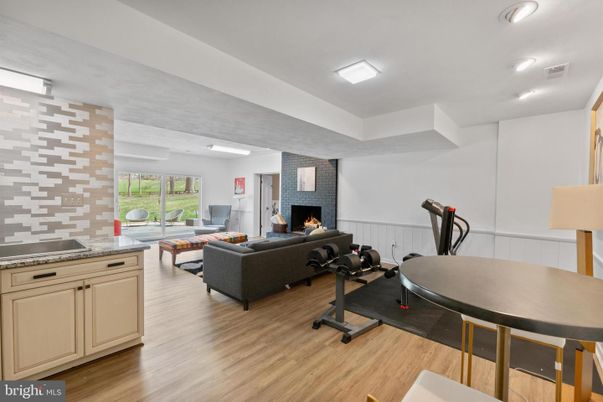 Fireplace, Fitness Equipment, Interior, Living room, Recessed Lighting, Stone Walls, Wood Texture Flooring