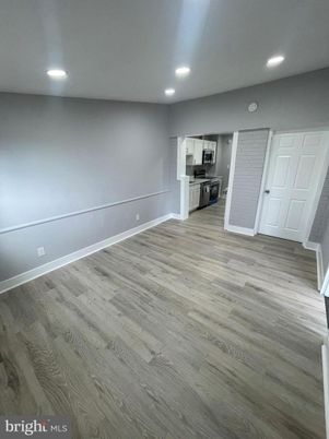 Empty room, Interior, Kitchen, Recessed Lighting, Stainless Steel Appliances, Wood Texture Flooring