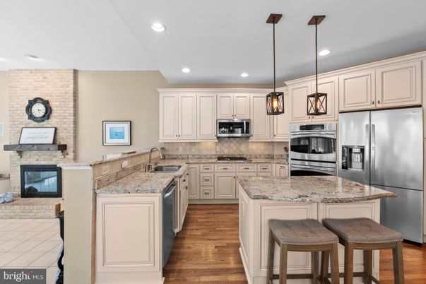 Fireplace, Interior, Kitchen, Pendant Lights, Recessed Lighting, Stainless Steel Appliances, Stone Walls, Wood Texture Flooring
