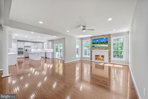 Empty room, Fireplace, Interior, Kitchen, Pendant Lights, Recessed Lighting, Stainless Steel Appliances, Stone Walls, Wood Texture Flooring