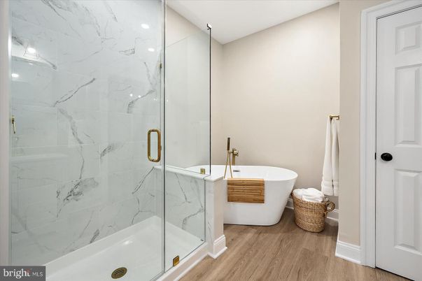 Bathroom, Free Standing Baths, Glass Shower, Interior, Marble Walls, Recessed Lighting, Wood Texture Flooring