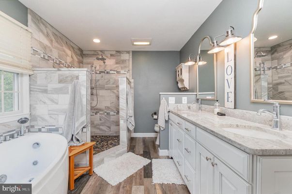 Bathroom, Dual Sink Vanities, Glass Shower, Interior, Marble Walls, Recessed Lighting, Wood Texture Flooring