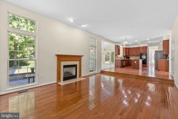 Empty room, Fireplace, Interior, Kitchen, Recessed Lighting, Stainless Steel Appliances, Wood Texture Flooring