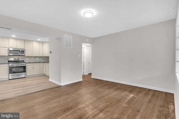 Empty room, Interior, Kitchen, Recessed Lighting, Stainless Steel Appliances, Wood Texture Flooring