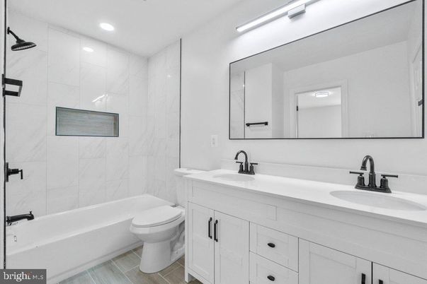 Bathroom, Dual Sink Vanities, Interior, Marble Walls, Recessed Lighting, Wood Texture Flooring