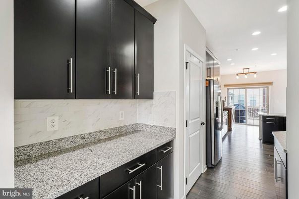 Interior, Kitchen, Marble Walls, Recessed Lighting, Washer, Wood Texture Flooring