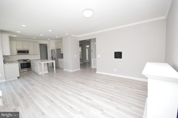 Empty room, Interior, Kitchen, Recessed Lighting, Stainless Steel Appliances, Wood Texture Flooring