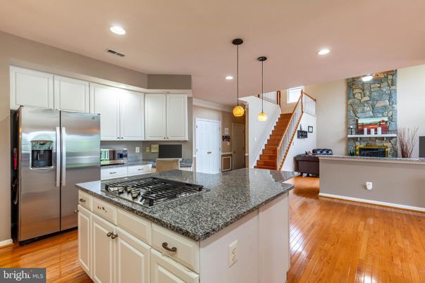 Fireplace, Interior, Kitchen, Pendant Lights, Recessed Lighting, Stainless Steel Appliances, Stone Walls, Wood Texture Flooring