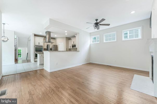 Empty room, Fireplace, Interior, Kitchen, Recessed Lighting, Stainless Steel Appliances, Wood Texture Flooring