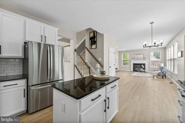 Chandelier, Fireplace, Interior, Kitchen, Living room, Pendant Lights, Recessed Lighting, Stainless Steel Appliances, Wood Texture Flooring