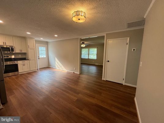 Empty room, Interior, Kitchen, Recessed Lighting, Stainless Steel Appliances, Wood Texture Flooring