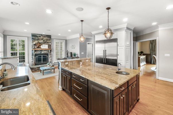 Fireplace, Interior, Kitchen, Living room, Pendant Lights, Recessed Lighting, Stainless Steel Appliances, Stone Walls, Wood Texture Flooring