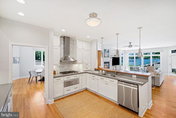 Dining room, Fireplace, Interior, Kitchen, Pendant Lights, Recessed Lighting, Stainless Steel Appliances, Water, Wood Texture Flooring