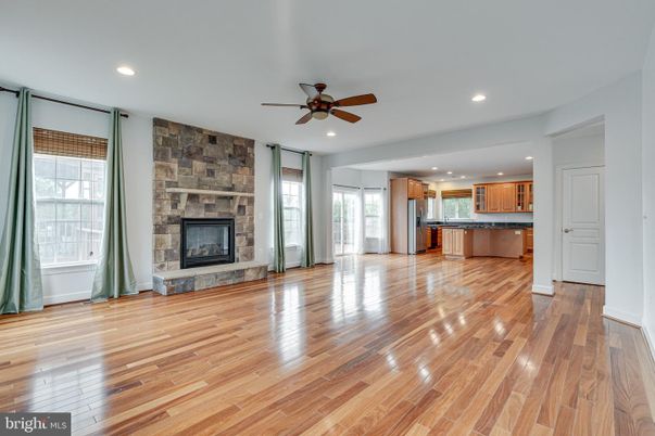 Empty room, Fireplace, Interior, Kitchen, Recessed Lighting, Stainless Steel Appliances, Stone Walls, Wood Texture Flooring