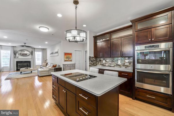 Chandelier, Fireplace, Interior, Kitchen, Living room, Pendant Lights, Recessed Lighting, Stainless Steel Appliances, Wood Texture Flooring