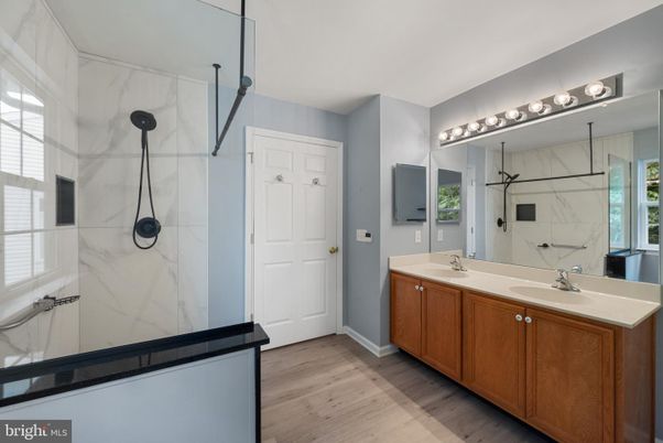 Bathroom, Dual Sink Vanities, Glass Shower, Interior, Marble Walls, Wood Texture Flooring