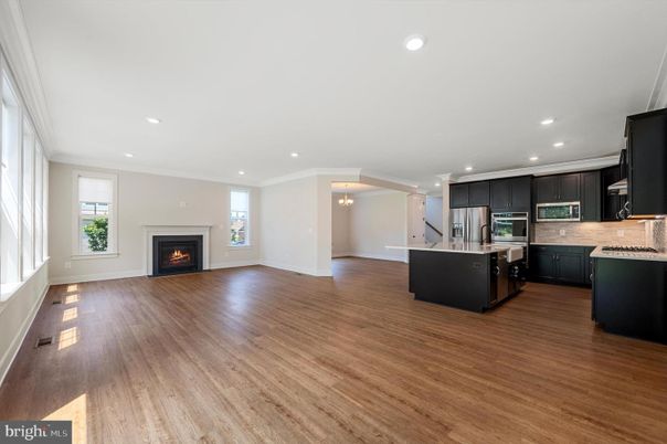 Chandelier, Empty room, Fireplace, Interior, Kitchen, Recessed Lighting, Stainless Steel Appliances, Wood Texture Flooring