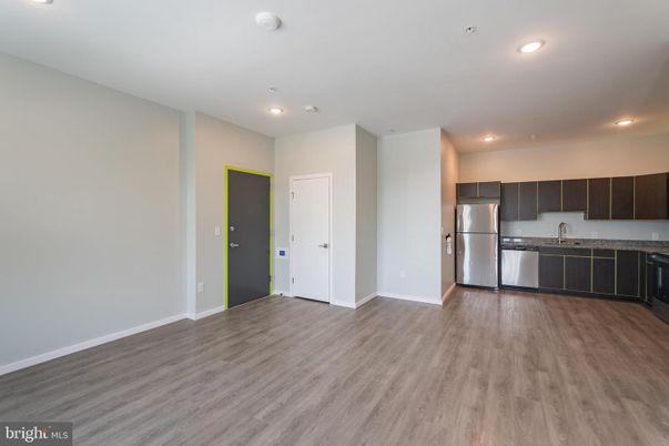 Empty room, Interior, Kitchen, Recessed Lighting, Stainless Steel Appliances, Wood Texture Flooring