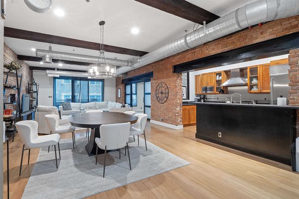 Chandelier, Dining room, Interior, Kitchen, Living room, Pendant Lights, Recessed Lighting, Stainless Steel Appliances, Stone Walls, Wooden Beams, Wood Texture Flooring