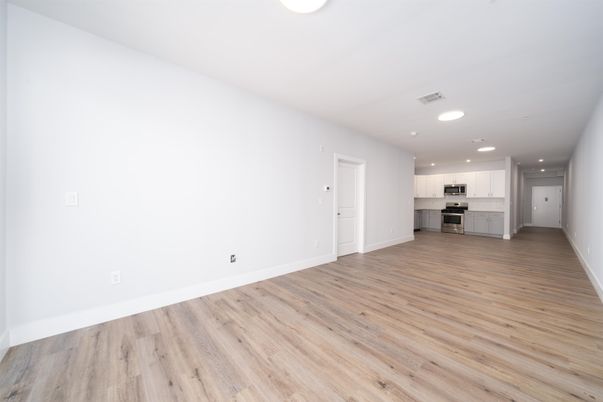 Empty room, Interior, Kitchen, Recessed Lighting, Stainless Steel Appliances, Wood Texture Flooring