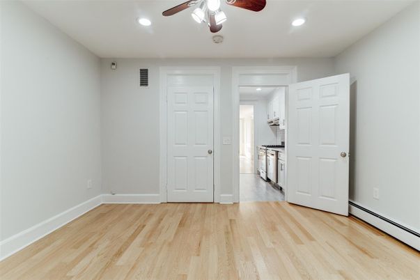 Empty room, Interior, Kitchen, Recessed Lighting, Stainless Steel Appliances, Wood Texture Flooring