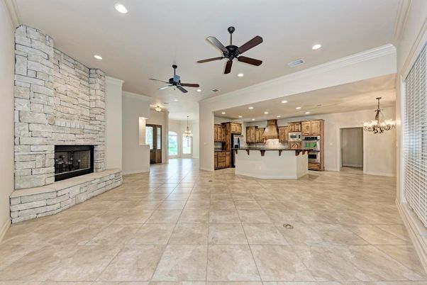 Chandelier, Empty room, Fireplace, Interior, Kitchen, Pendant Lights, Recessed Lighting, Stainless Steel Appliances, Stone Walls