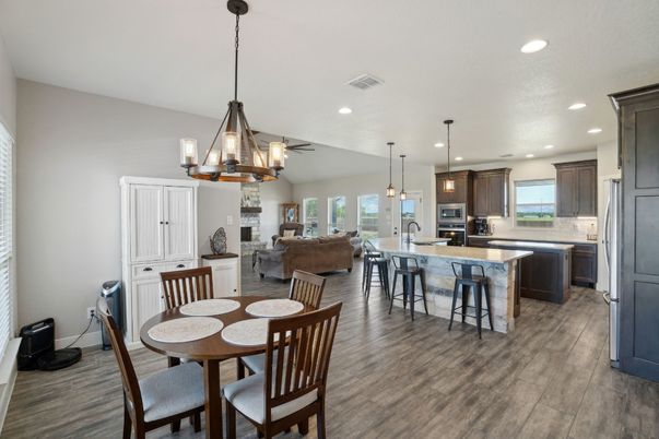 Chandelier, Dining room, Fireplace, Interior, Kitchen, Living room, Pendant Lights, Recessed Lighting, Stainless Steel Appliances, Wood Texture Flooring