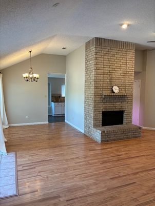 Chandelier, Empty room, Fireplace, Interior, Recessed Lighting, Stone Walls, Wood Texture Flooring