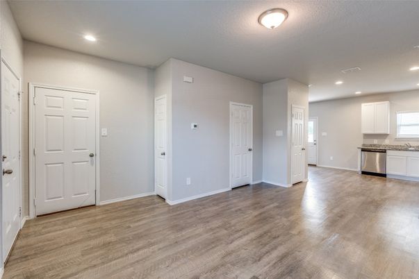 Empty room, Interior, Kitchen, Recessed Lighting, Stainless Steel Appliances, Wood Texture Flooring
