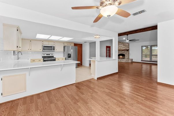 Empty room, Fireplace, Interior, Kitchen, Stainless Steel Appliances, Stone Walls, Wood Texture Flooring