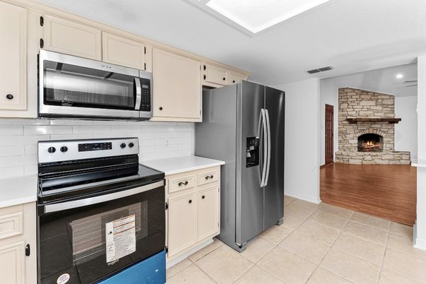 Fireplace, Interior, Kitchen, Recessed Lighting, Stainless Steel Appliances, Stone Walls, Wood Texture Flooring