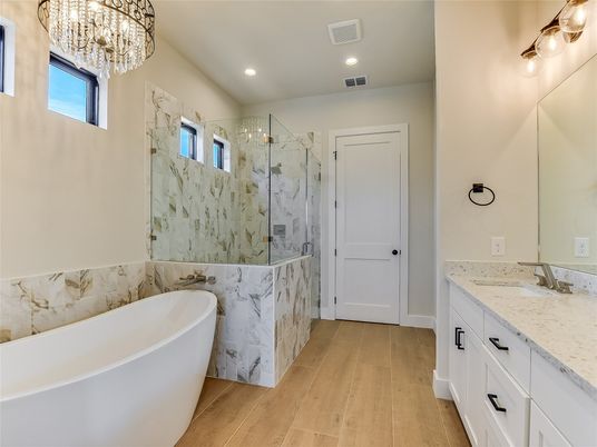Bathroom, Chandelier, Dual Sink Vanities, Free Standing Baths, Glass Shower, Interior, Marble Walls, Recessed Lighting, Wood Texture Flooring